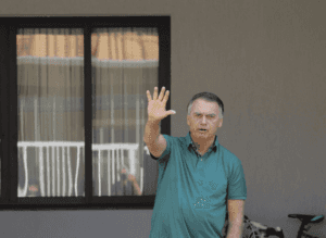 Em prisão domiciliar, Bolsonaro acena para jornalistas na porta de casa